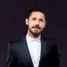 Ing. Bernhard Lutz, MSc. in dunklem Sakko und weißem Hemd, freundlicher Blick, dunkler Hintergrund
